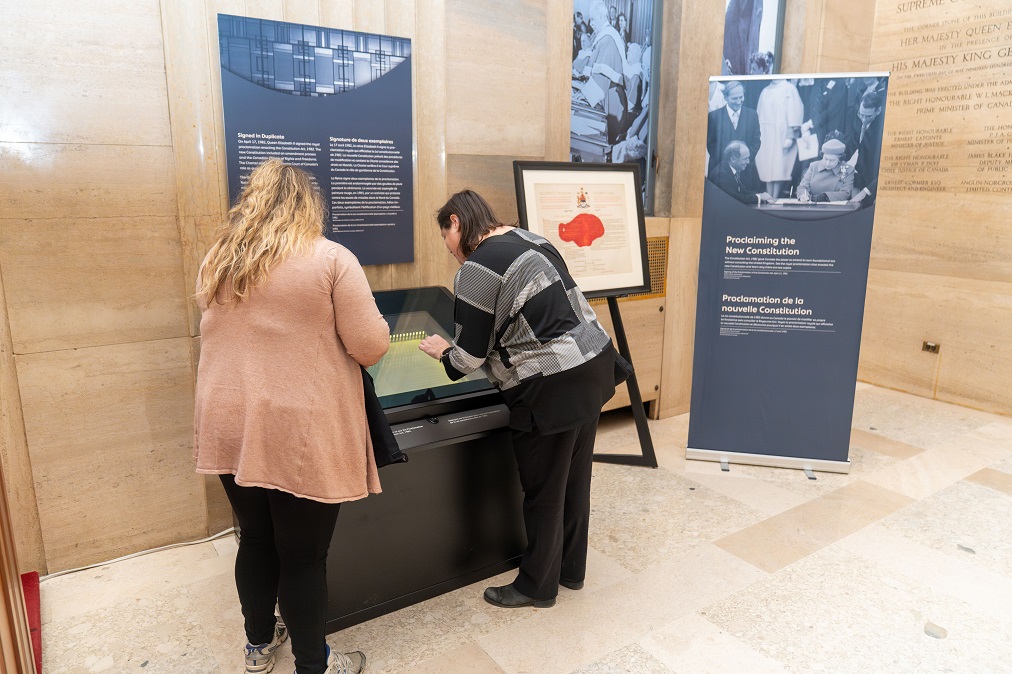 Visiteurs qui consultent la proclamation de la Loi constitutionnelle de 1982