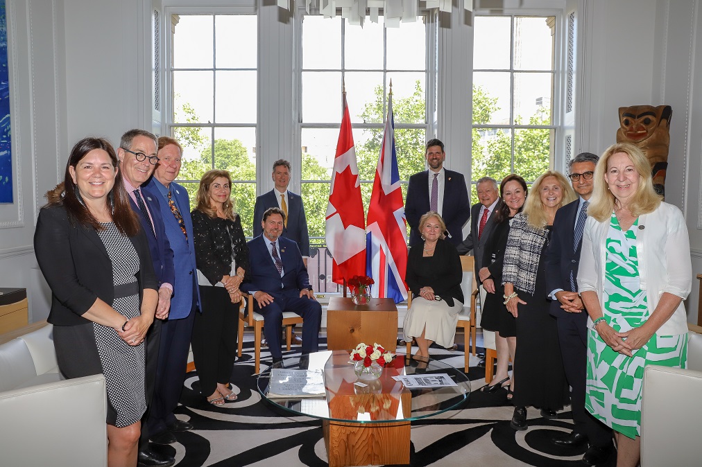 Judges of the Supreme Court pose with various dignitaries in front of Canadian and British flags