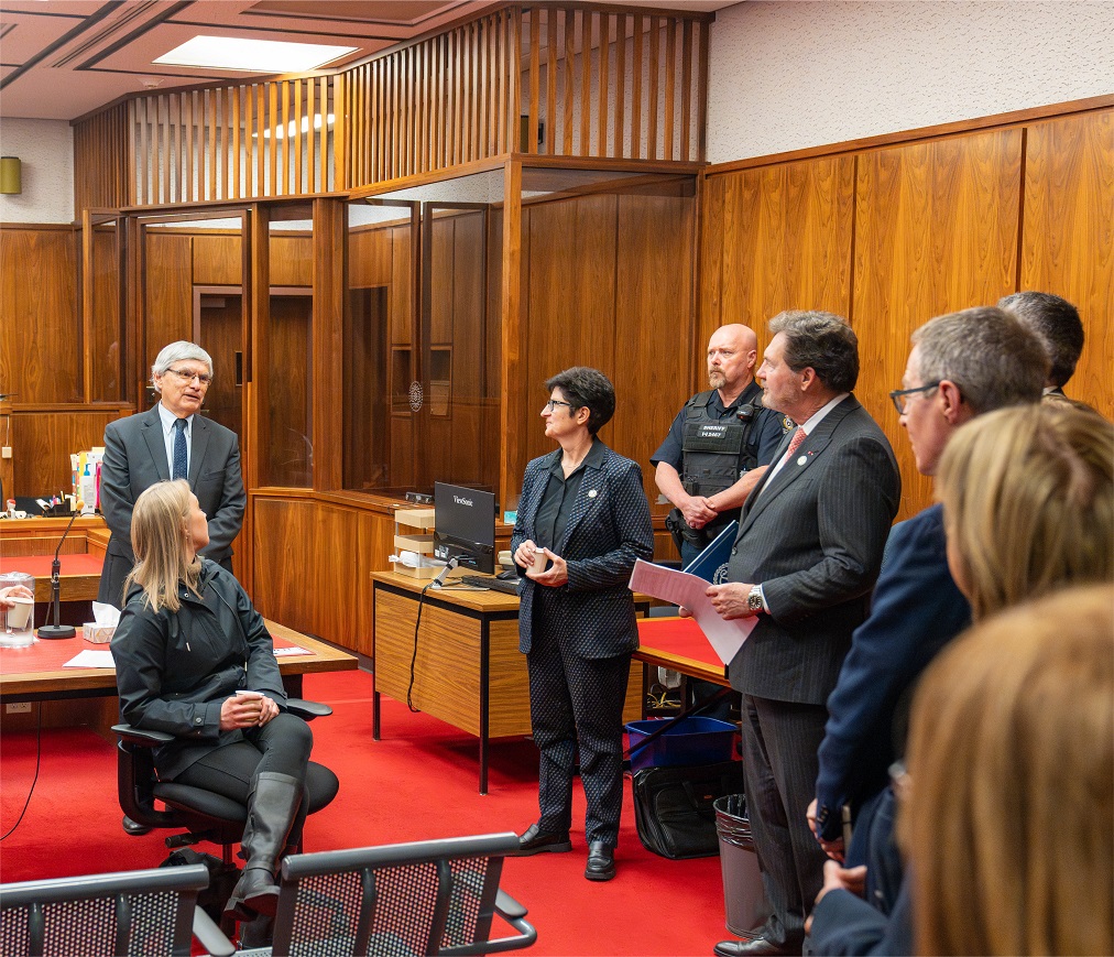 Chief Justice Wagner, Justice Kasirer and Supreme Court representatives discuss with staff in a courtroom