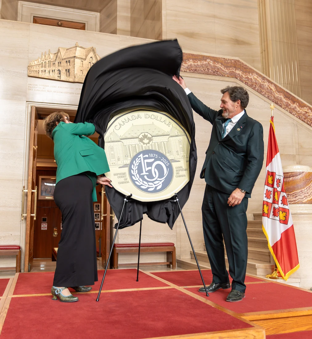 Chief Justice Wagner and Royal Canadian Mint President Marie Lemay unveil an oversized replica of the $1 coin