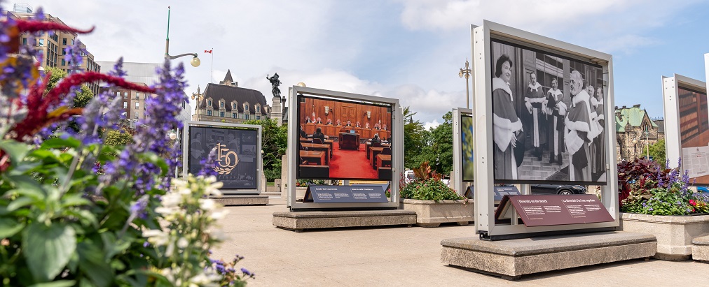 Large photo panels displayed on Plaza Bridge with Parliament Hill in the background