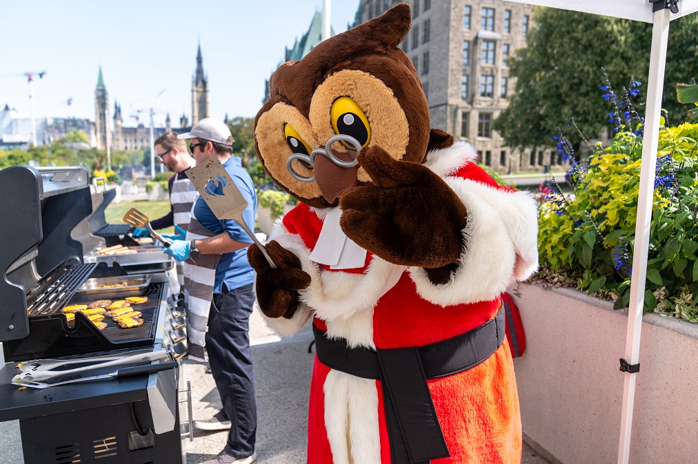 Amicus, the Supreme Court’s mascot, cooks burgers with staff at a BBQ