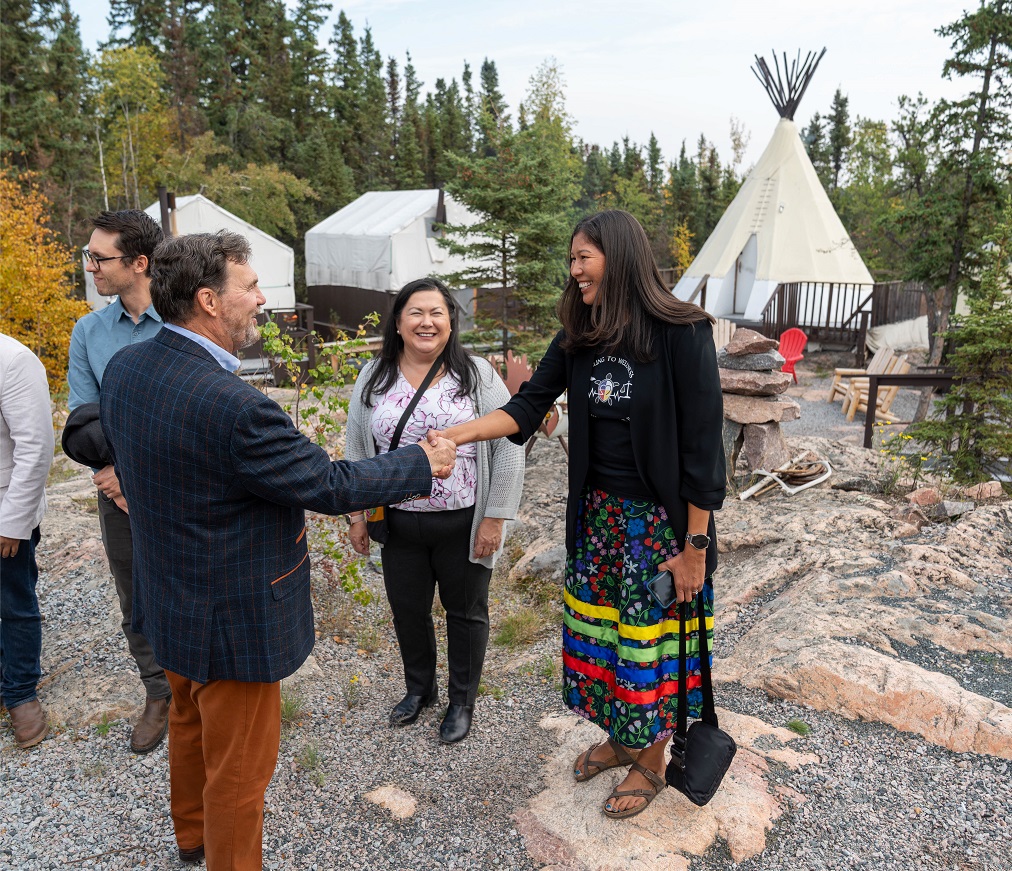 Chief Justice Wagner shakes hands with a woman in a ribbon skirt