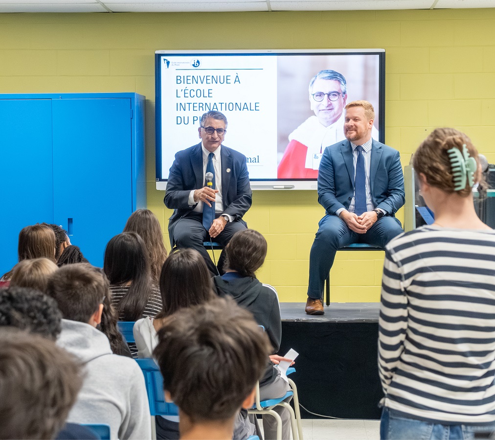 Justice Jamal speaks to students while sitting on a stage