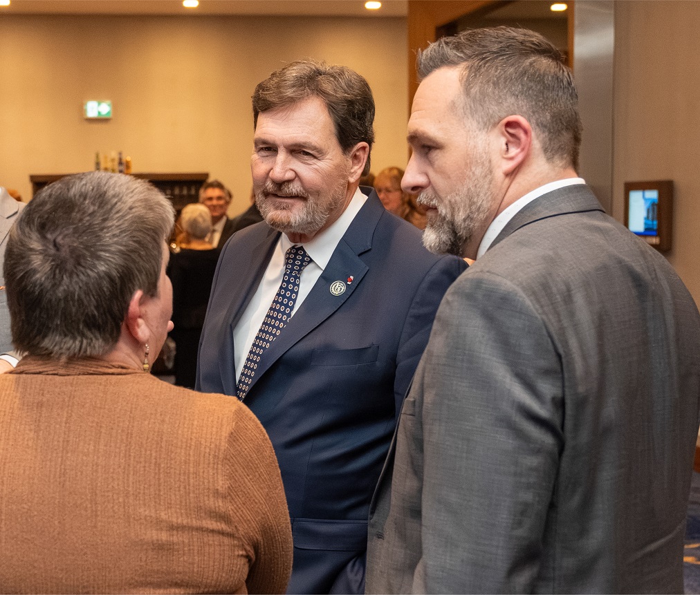 Chief Justice Wagner speaks to 2 people at a reception
