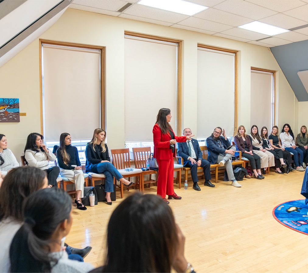 Justice O’Bonsawin speaks to students in a large room with decorated with Indigenous art