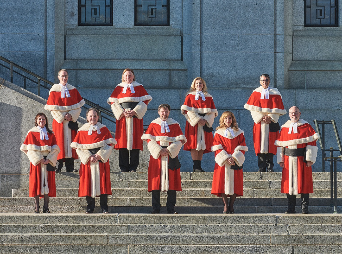Judges wearing their red robes in front of the building