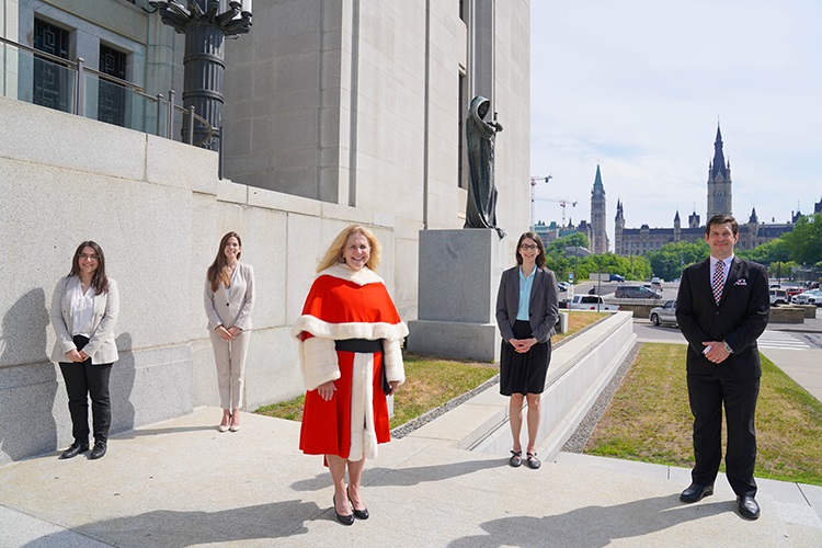 Justice Martin and her law clerks in front of the building